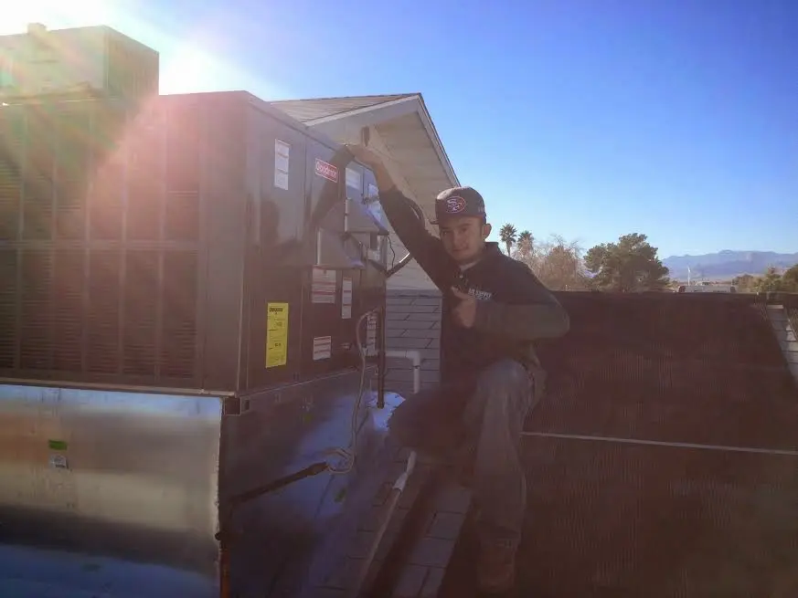 HVAC technician performing Boiler Repair on a rooftop unit in Warrenton